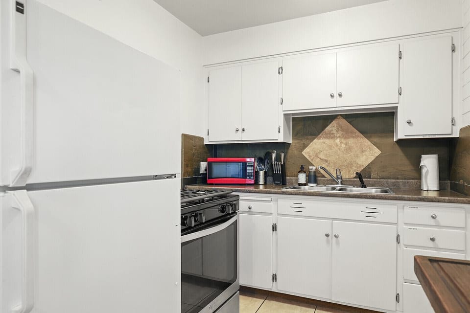 Kitchen includes dishwasher, fridge, stove top, coffee maker, toaster oven, pots and pans, plates, portable food containers, and utensils.