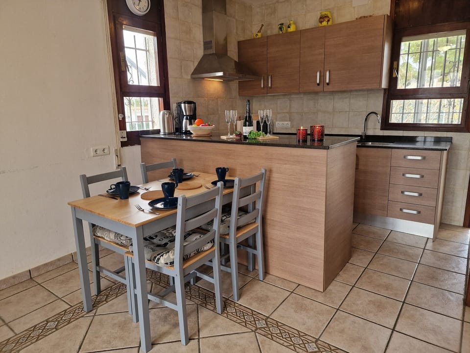 The central dining area in House Noella with a direct view of the modern kitchen counter and fully equipped kitchen.