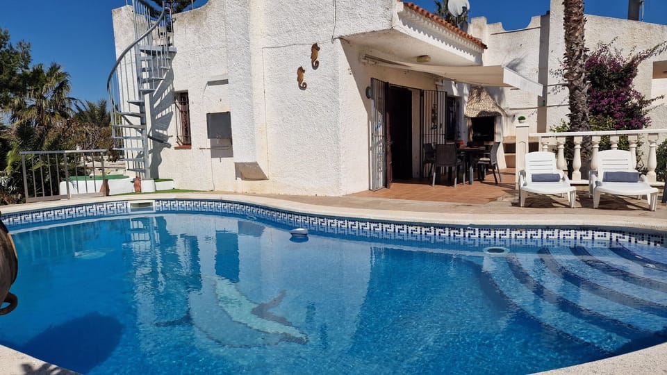 View across the crystal blue water of the 8.20m pool directly towards the inviting, shaded terrace of House Noella.