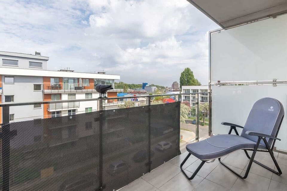 A small outdoor dining setup on the balcony, complete with dishes and a bottle of wine.