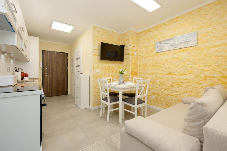 Another angle of the living room showing the yellow walls, a small coffee table, and a cozy couch.