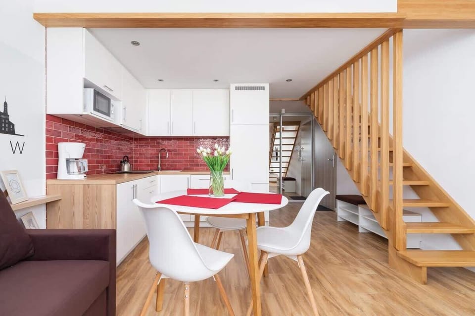 View of the open studio layout combining the bed, dining area, and kitchenette under charming slanted ceilings.