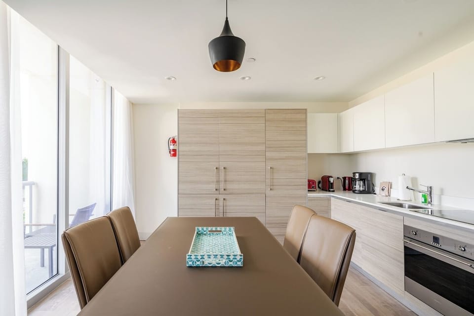 Cocina comedor moderna y lujosa en este hotel de 4 estrellas. Diseñada con elegancia y funcionalidad, cuenta con electrodomésticos de alta gama y un ambiente acogedor, perfecto para disfrutar de comidas con comodidad y estilo.