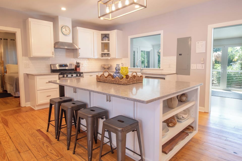 Gather around the spacious island in your fully equipped kitchen, where gleaming countertops and modern appliances invite you to prepare delicious meals while soaking in natural light from the surrounding windows.