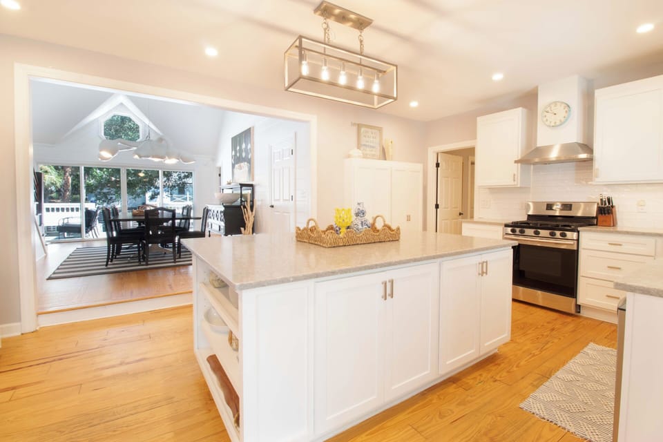 Bright, open kitchen with a spacious island where you can gather for morning coffee or meal prep. Warm hardwood floors and modern appliances make this the heart of your home away from home.
