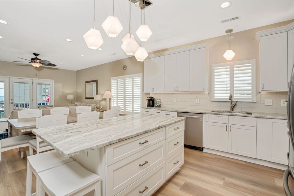 Your gourmet kitchen awaits with marble countertops, geometric pendant lighting, and premium appliances—perfect for creating memorable meals together.