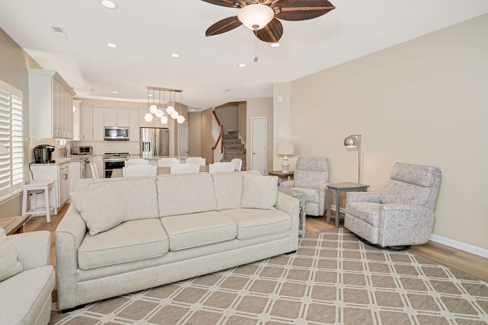 Unwind in your spacious living room where plush sofas and modern comfort blend seamlessly with the open kitchen.