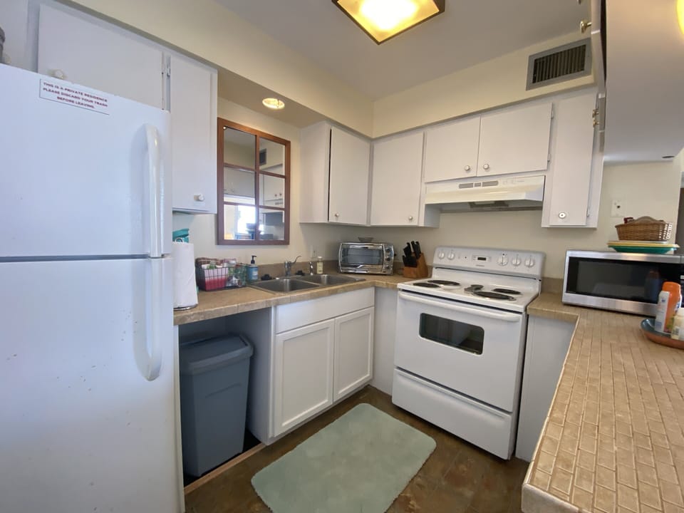 Full kitchen with stove, microwave and full size refrigerator. Dish wares