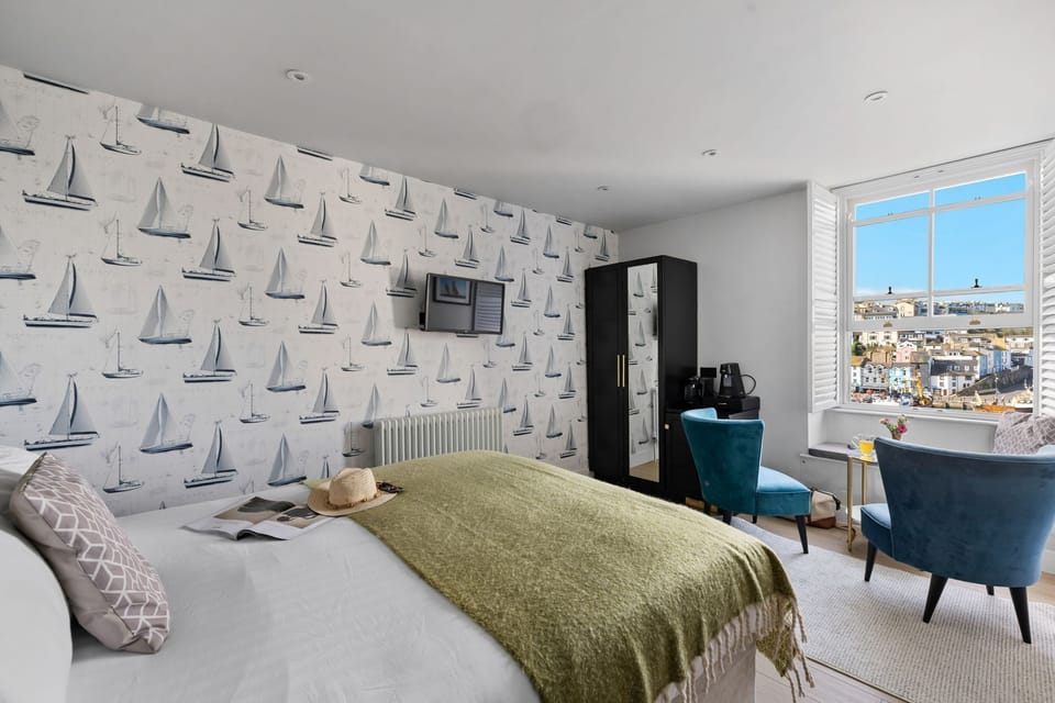 Bed with TV view, wardrobe and seating area - Leader Suite