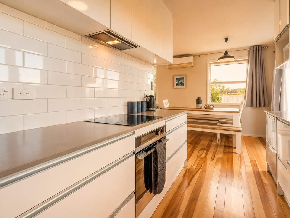 Kitchen has an eclectic hob and oven, microwave, and dishwasher.