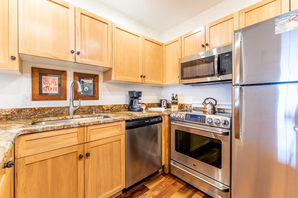 Whip up your favorite meals in this well-equipped kitchen featuring granite countertops, stainless steel appliances, and warm wood cabinetry.