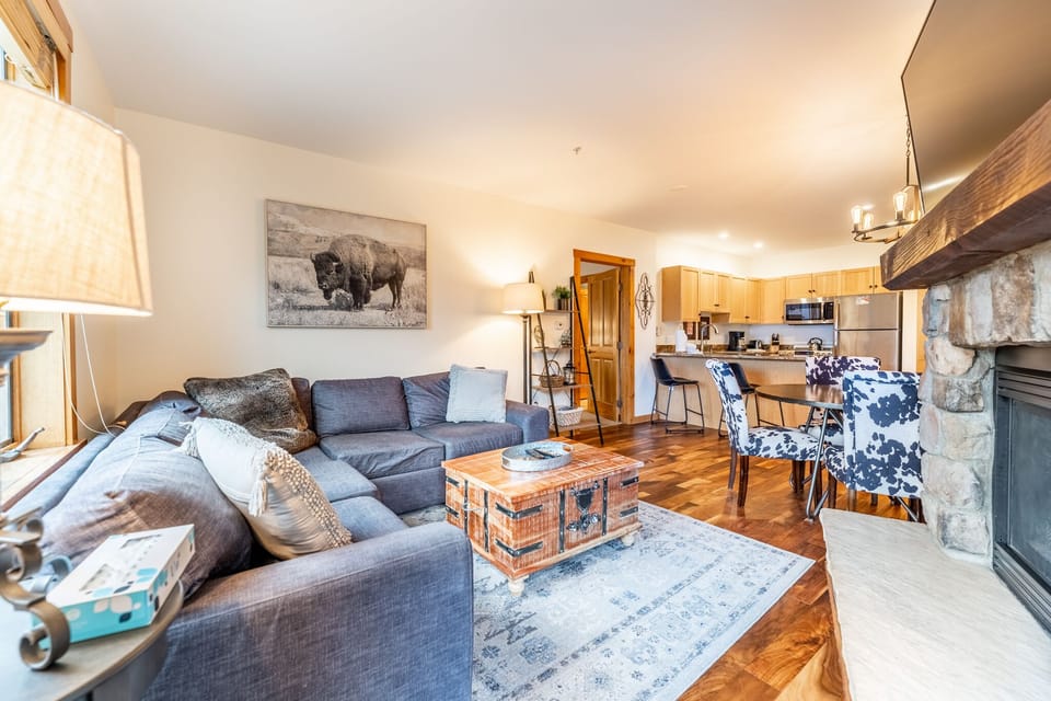 Sink into plush sofas by the stone fireplace, where rustic charm meets modern comfort in your cozy mountain retreat.