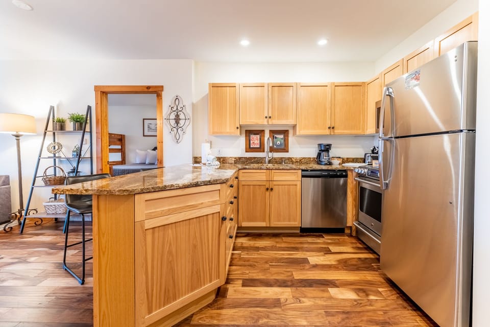 Your fully equipped kitchen awaits with granite counters, stainless appliances, and warm wood cabinetry for memorable meal prep.