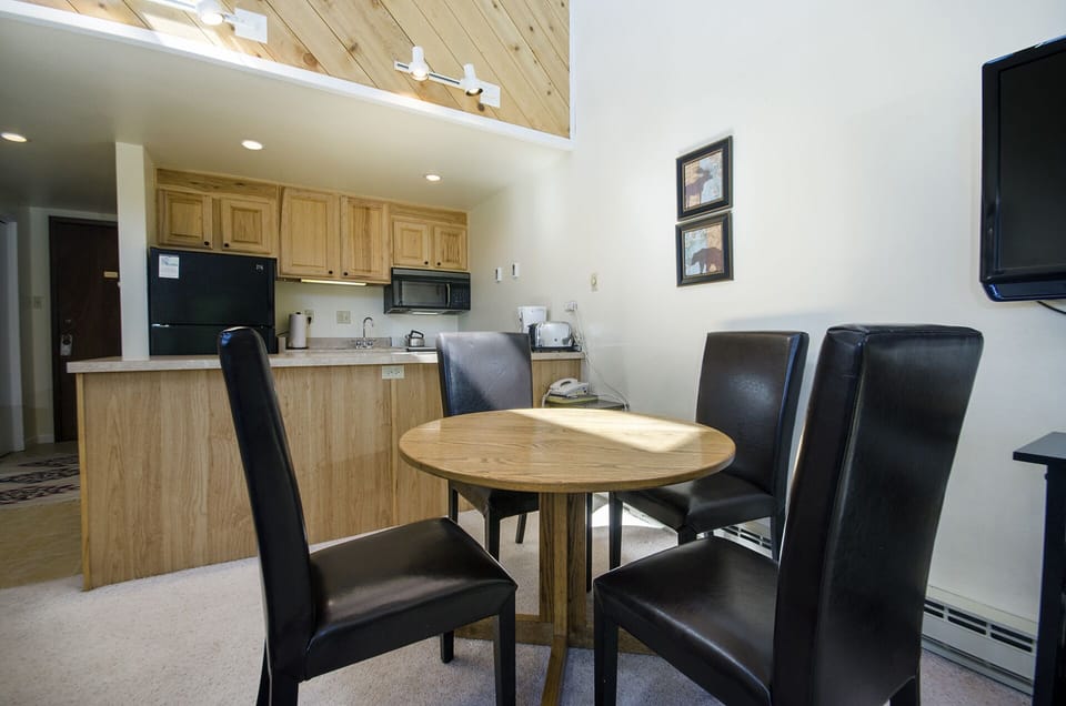 Your open-concept kitchen and dining space features warm wood cabinetry, modern appliances, and cozy seating for intimate meals together.