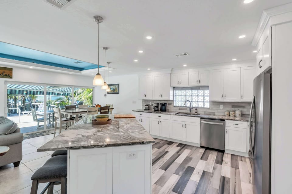 The open concept kitchen has a large island and a stainless steel package of appliances 