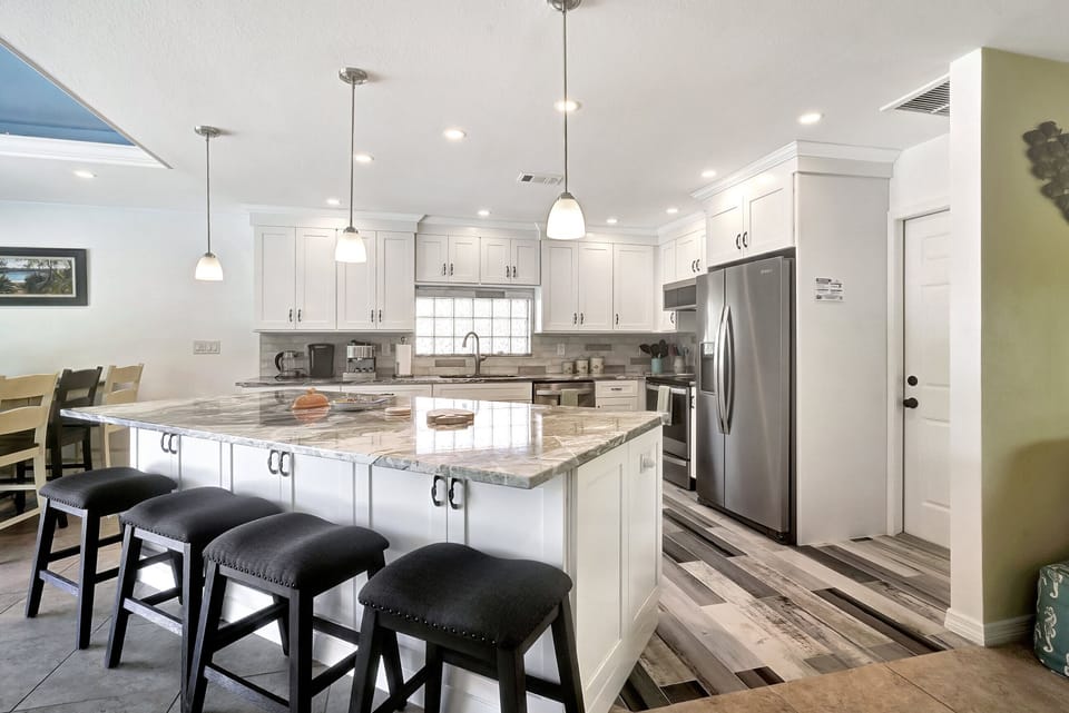 There is a large island that anchors the kitchen and provides additional seating space