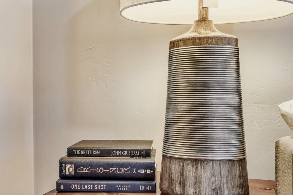 Your reading nook awaits with a stunning ceramic lamp and curated books, creating the perfect ambiance for quiet evenings.