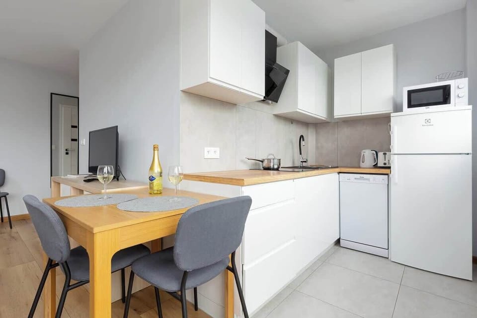 Fully equipped kitchenette with modern appliances and dining table.