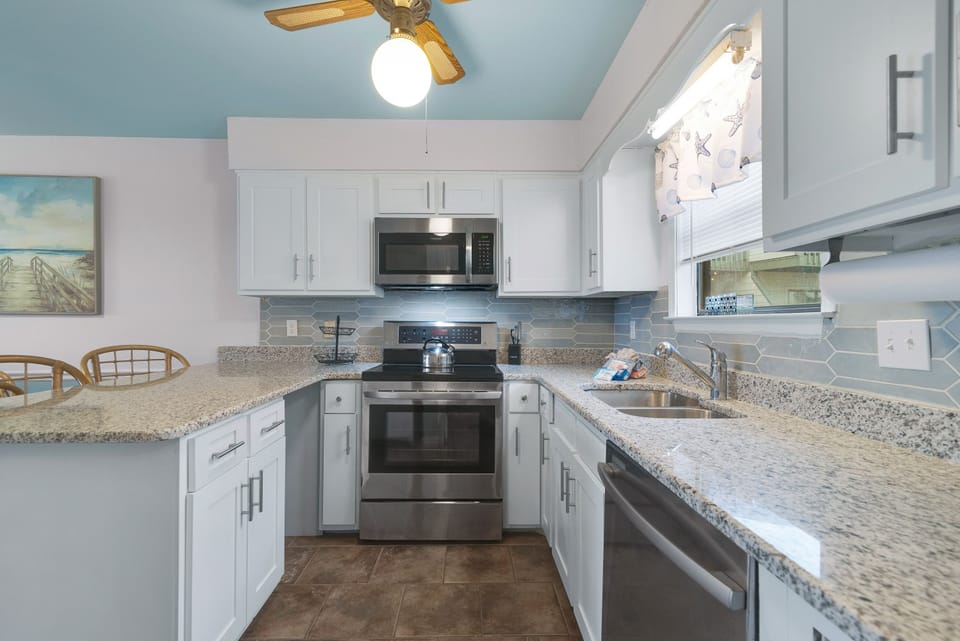 This gourmet kitchen, featuring stainless steel appliances and granite countertops, seamlessly flows into the spacious living area, perfect for entertaining.