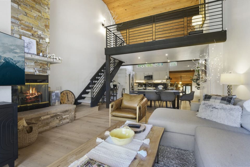 Living Room with Vaulted Wood Ceilings, a  Cozy Sofa and Flat Screen TV - Staircase leads to the Loft