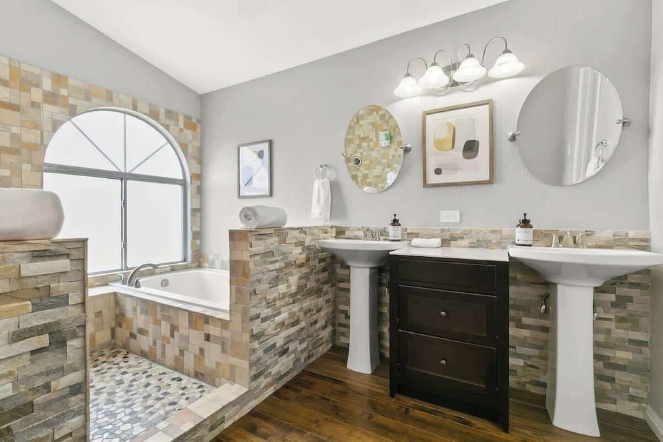 His and her vanity mirror, a luxurious bathtub, shower, thoughtful accents, plus towels and toiletries to complete your bathroom experience to either start or end your day here.
