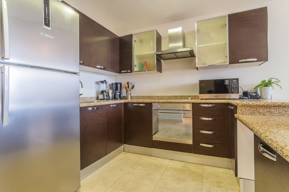 Palatine Kitchen of the lovely condo in Oranjestad Aruba - Integrated appliances for a seamless and stylish appearance - Aesthetic cohesion with matching hardware and fixtures - Harmony of textures, blending wood, metal, and stone elements.