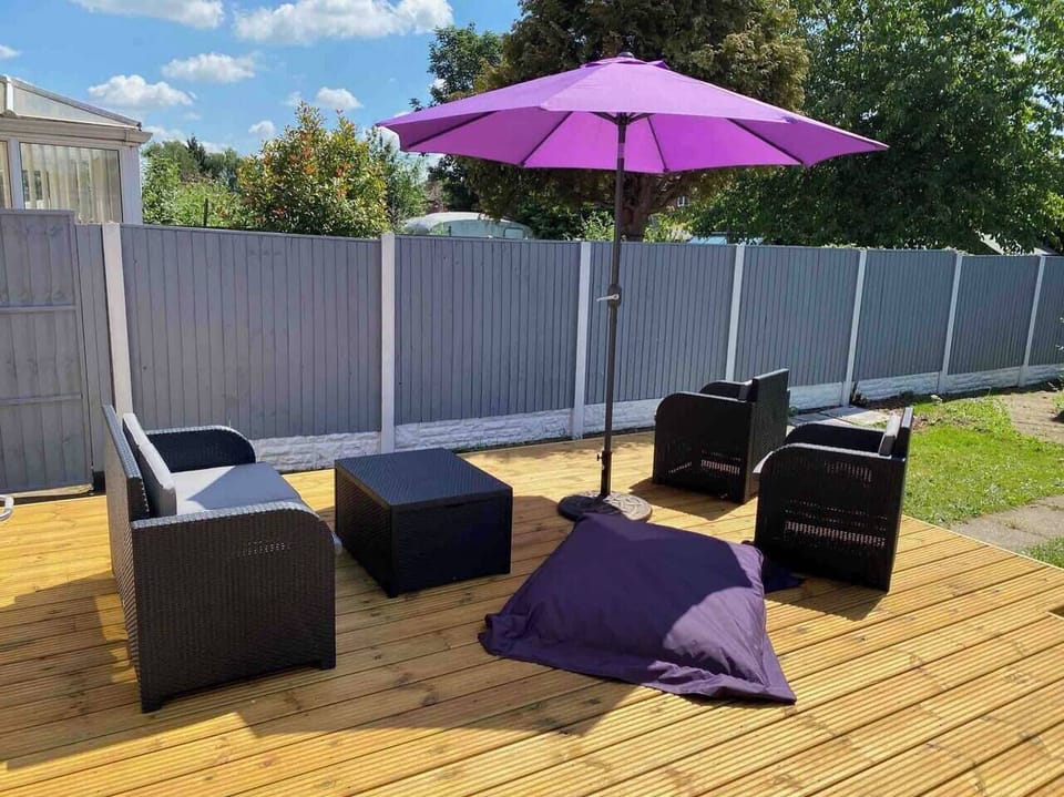 Rattan outdoor chairs on a spacious decking.
