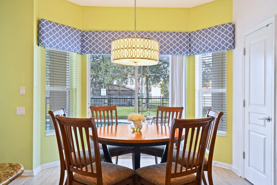 Cozy breakfast nook with natural light, stylish decor, and peaceful backyard views.