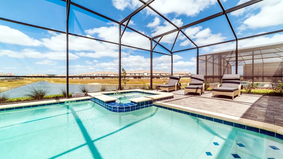 Private screened-in pool and spa with lake views and sunny lounge seating