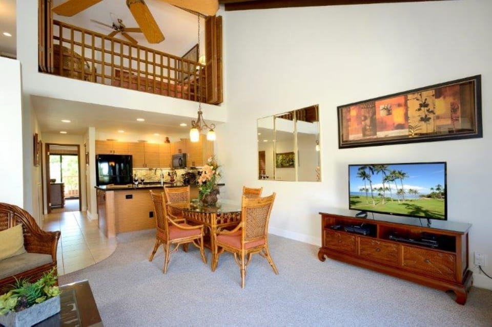 Relax in your spacious two-story retreat with vaulted ceilings, tropical wood accents, and an open layout connecting the living, dining, and kitchen areas—perfect for unwinding after island adventures.