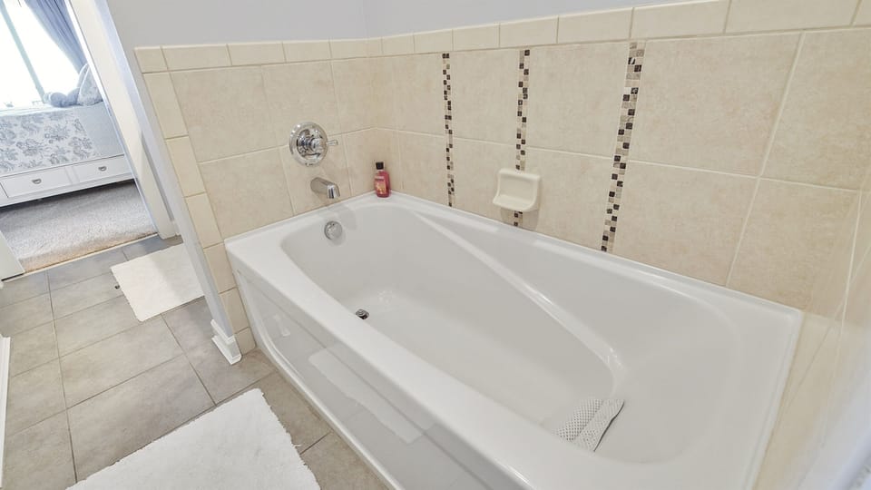 Sink into this pristine white soaking tub after your adventures. The elegant mosaic tile details create a spa-like atmosphere for your relaxing evening ritual.
