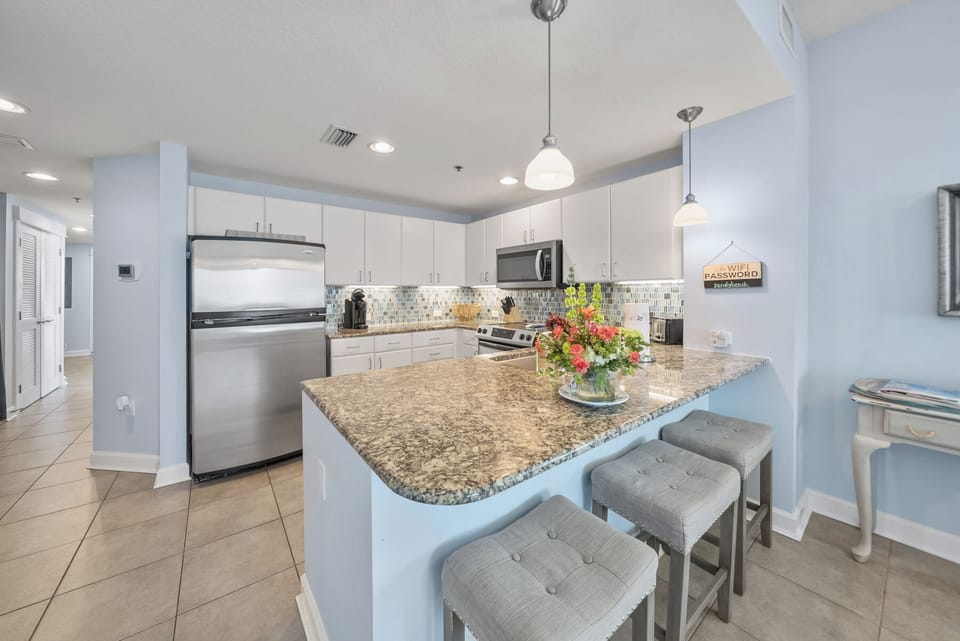 Your spacious kitchen features granite countertops, stainless appliances, and a convenient breakfast bar where you'll start each morning with fresh flowers brightening your space.