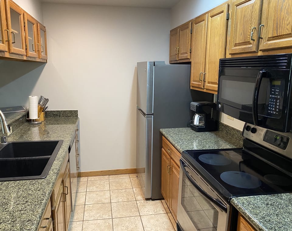 Fully stocked kitchen with new dishes, pots, pans, and coffee maker. 