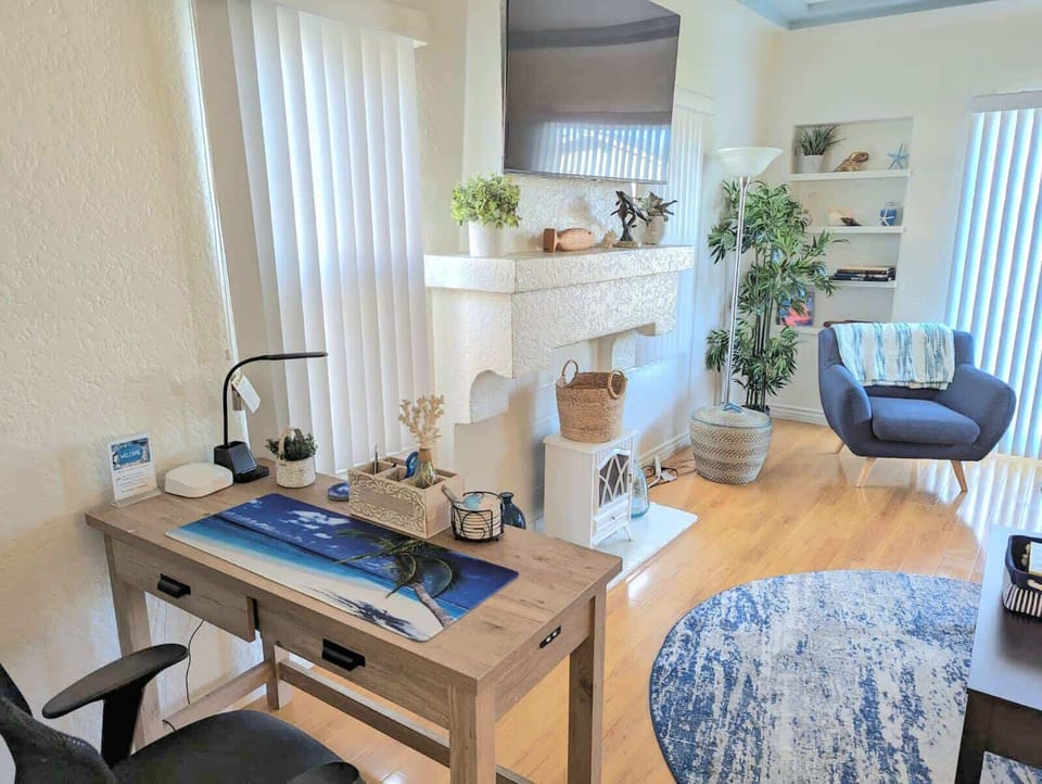 Great desk area with ergonomic chair, to work or play in this breezy, bright spacious living room.