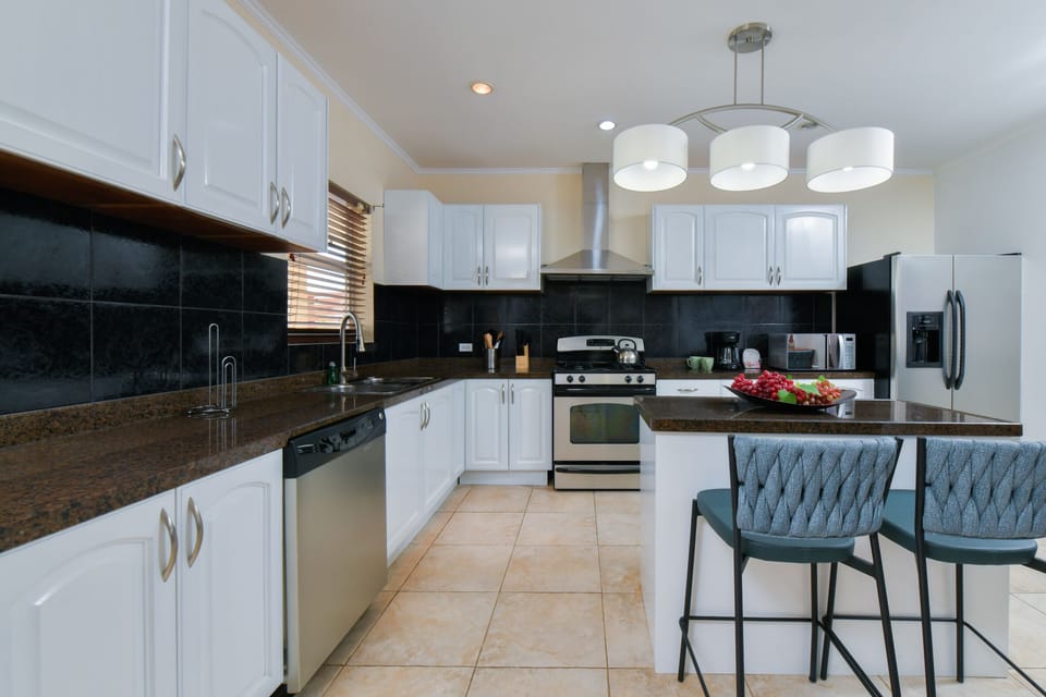 Panoramic Luxury and fully equipped Kitchen of the Villa in Noord, Aruba - Availability of all kitchen accessories - Ample amount of storage - Beautiful lighting with luxurious chandelier - 2 Marvellous high chairs available - Elegant decor