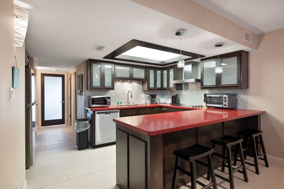 Modern kitchen with sleek finishes, bar seating, and stainless appliances
