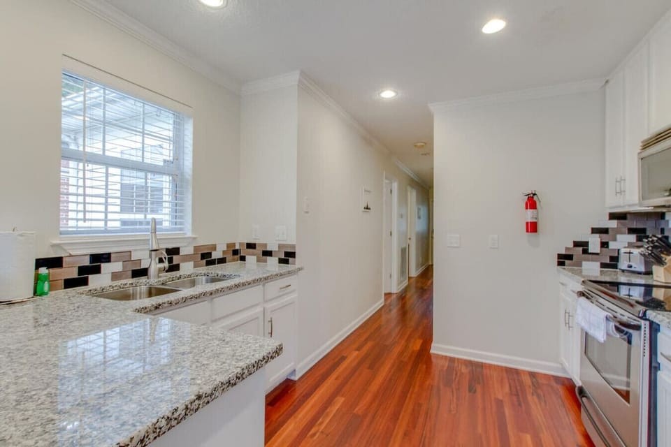Warm hardwood floors flow through the bright, open kitchen.