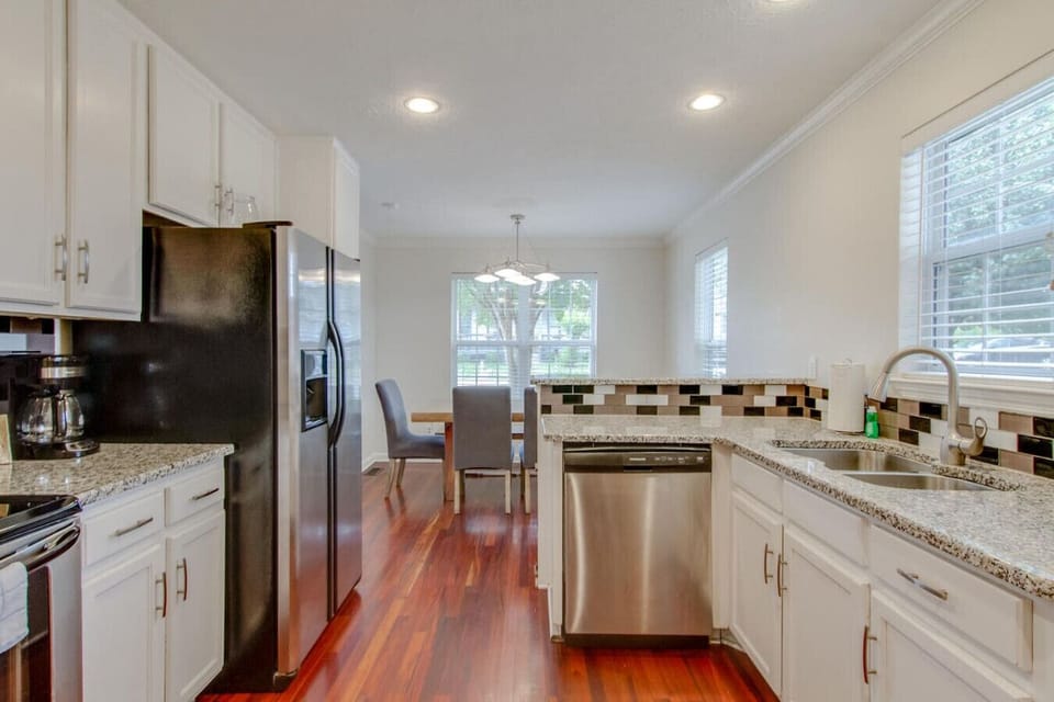 Fully stocked kitchen with stainless appliances and dining just beyond.