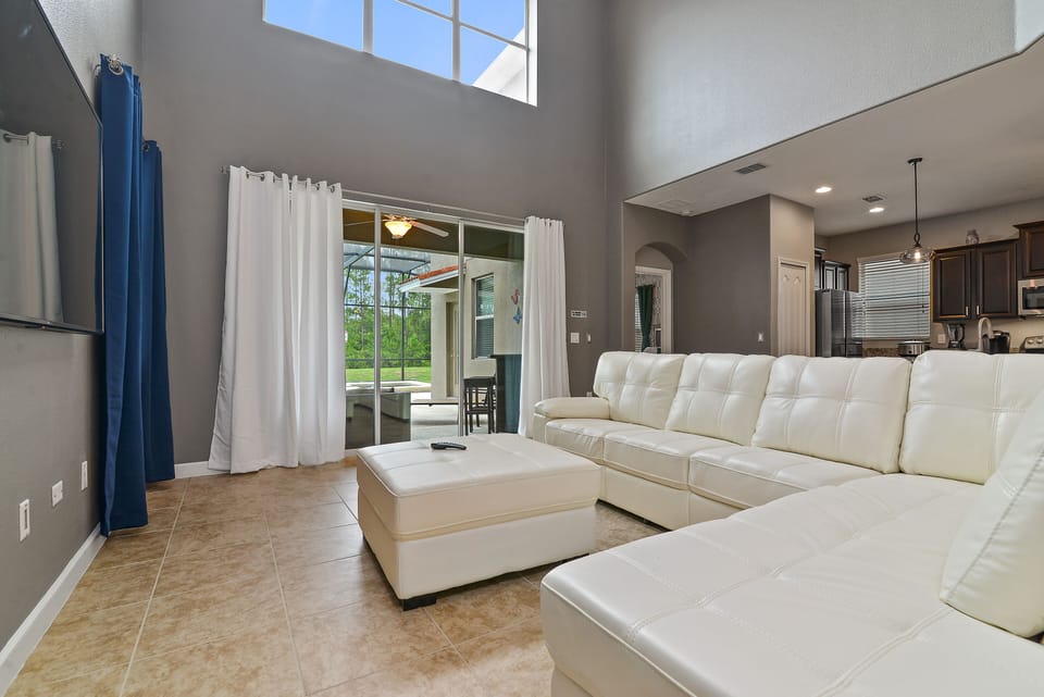Brand new white leather sofas with large smart TV and wide lanai patio doors