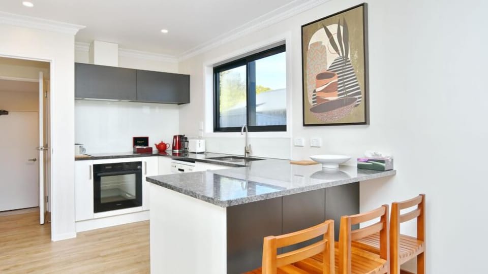 A kitchen set up for real cooking, with an island and bar seating to gather around.