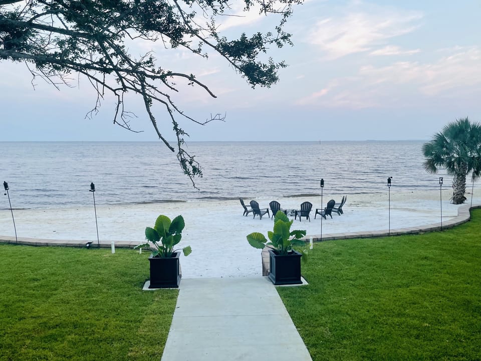 Professionally landscaped lawn leading onto your private 144 ft. beach. 