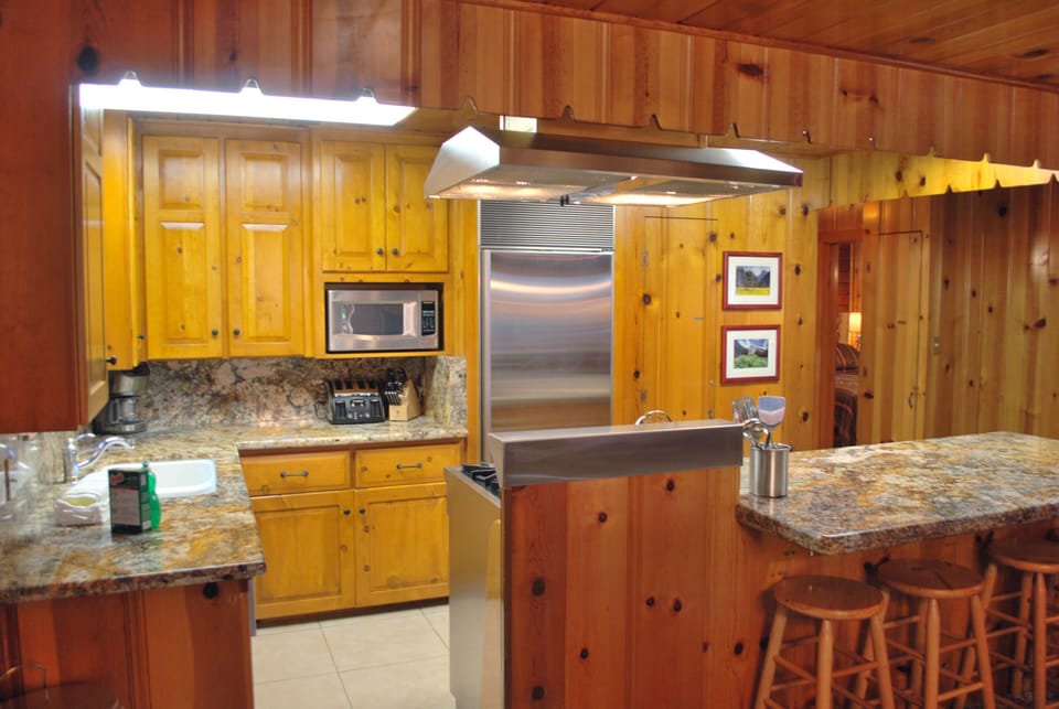 Kitchen area with stainless steel appliances, counter for additional seating