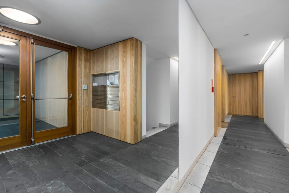 The entry hallway with warm wooden doors and clean, simple decor.