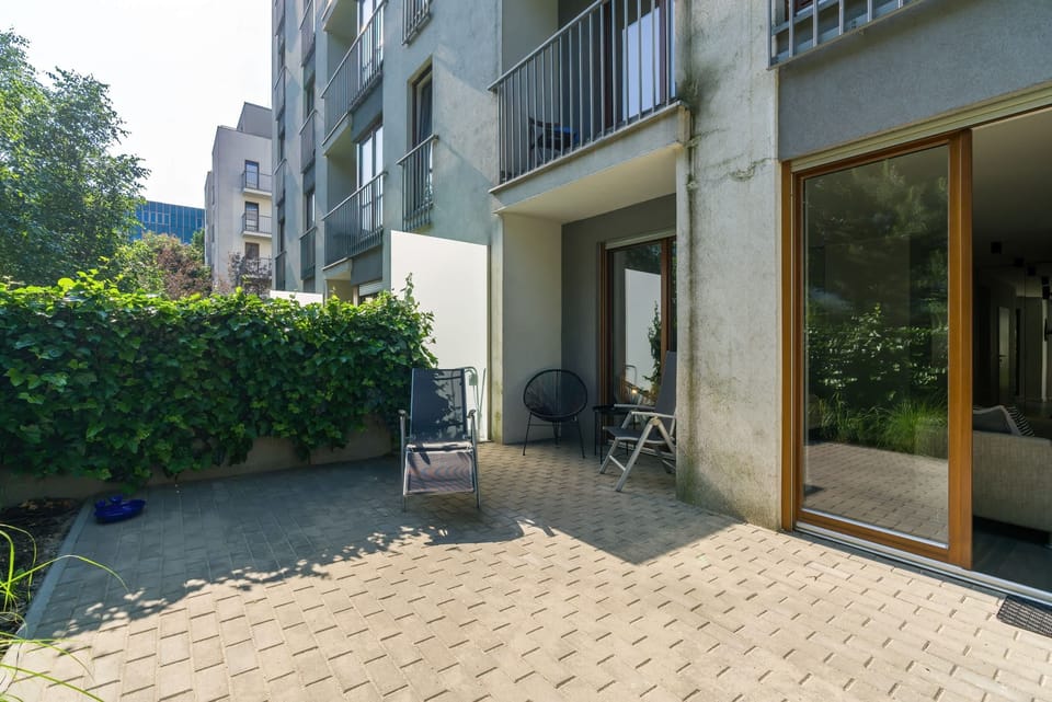 A closer look at the outdoor space, showcasing seating arrangements and a view of the garden.