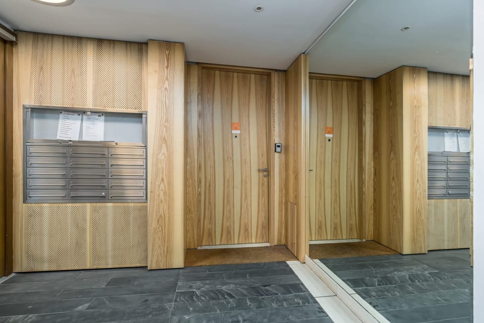 The entry hallway with warm wooden doors and clean, simple decor.