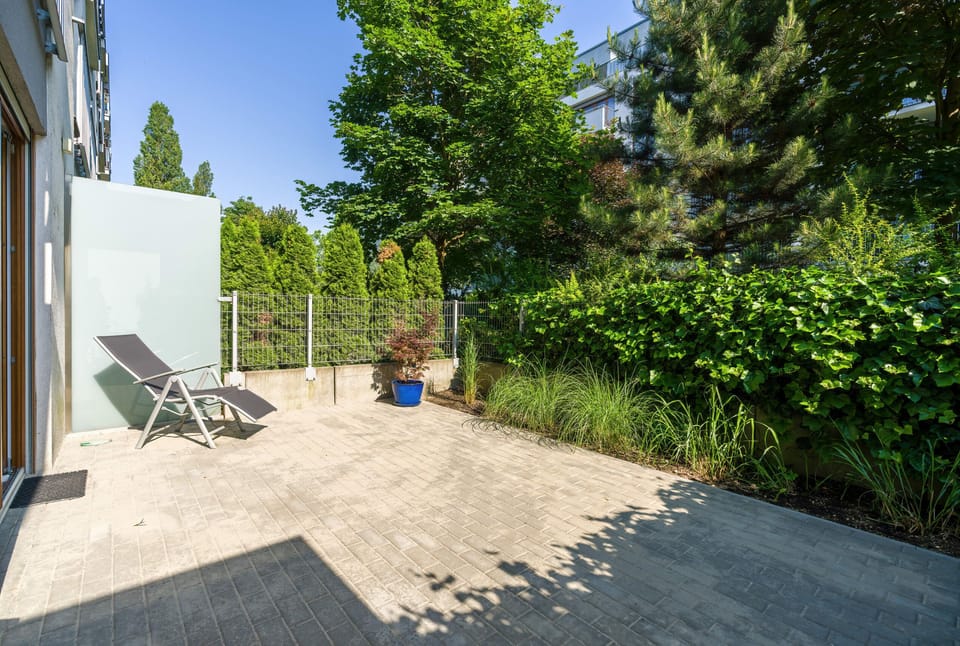 Furnished terrace surrounded by greenery.