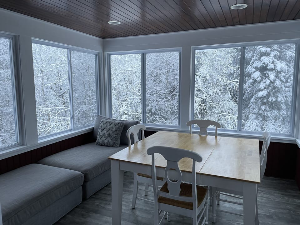 3 season room overlooking the brook with dinging table and lounge furniture