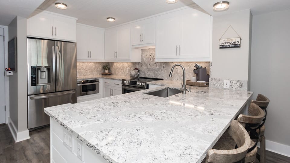 Updated and fully-stocked  kitchen with quartz counters & stainless appliances. 