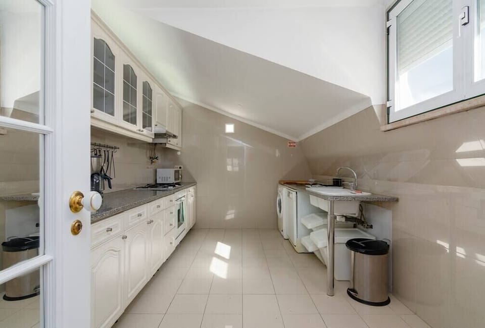 Cozinha com zona de lavandaria.