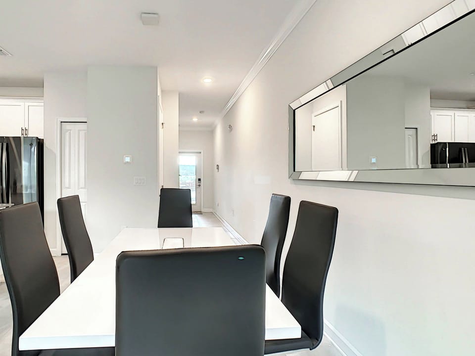 Modern dining area with sleek chairs and large wall mirror